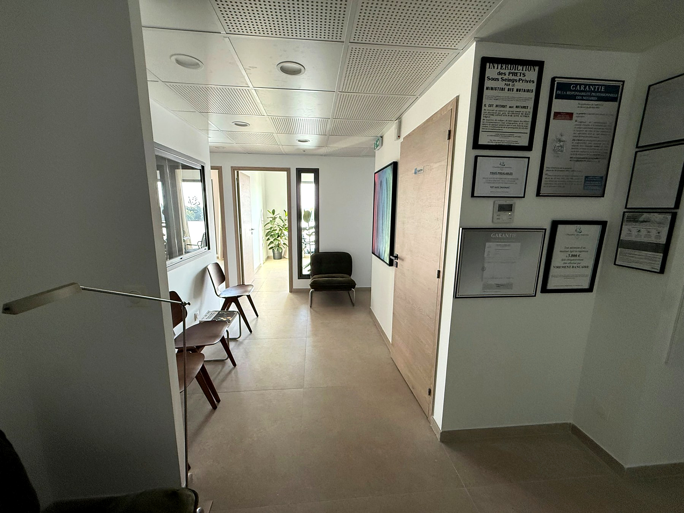 Couloir de l'office avec les affichages réglementaires du notariat